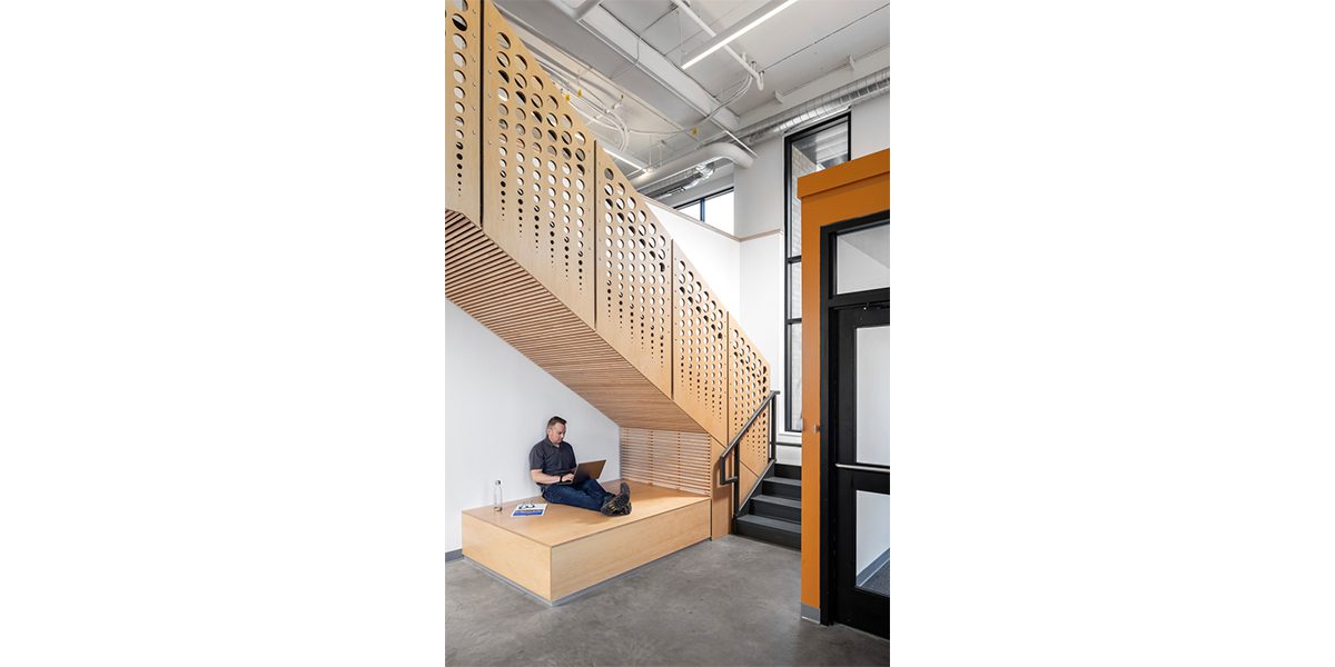 Man sitting under interior staircase