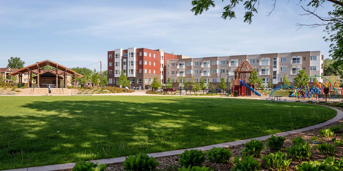 View of field and park with apartment building in the distance