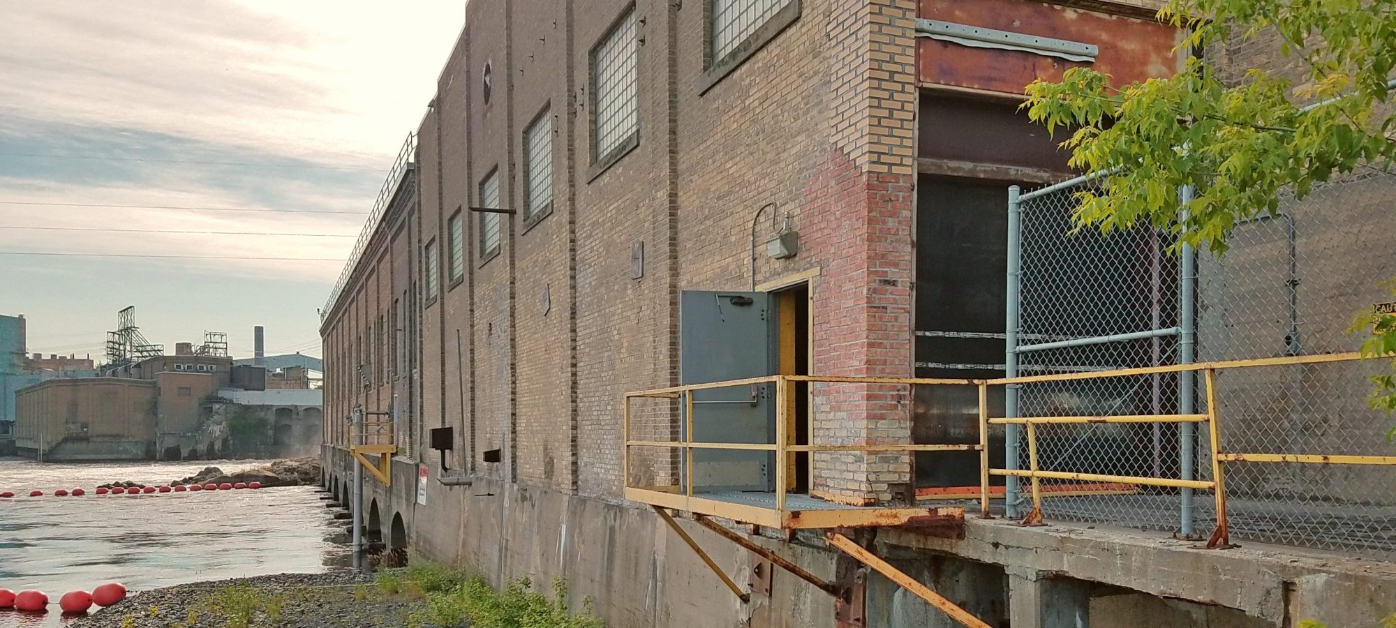Brick exterior of an industrial paper mill on a river